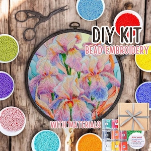 May include: DIY bead embroidery kit featuring a colorful floral design with a variety of beads in small bowls. The kit includes all the materials needed to complete the project, including a hoop, beads, and instructions.