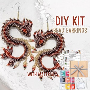 Op de afbeelding: DIY kralen oorbellen kit met draakvormige oorbellen. De oorbellen zijn gemaakt met bruine, rode en gouden kralen. De kit bevat materialen, instructies en een geschenkdoos met een zilveren lint.