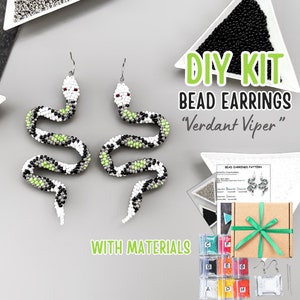 May include: DIY kit to make beaded snake earrings. The kit includes all the materials needed, including beads, thread, and earring hooks. The earrings are green, black, and white. The kit also includes a pattern for making the earrings.