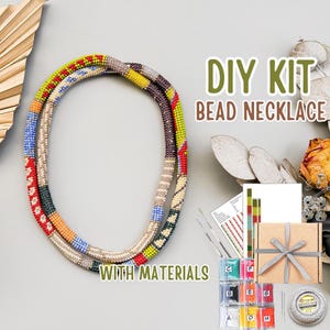 Könnte beinhalten: Ein DIY-Perlenketten-Set mit Materialien. Das Bild zeigt zwei farbenfrohe Perlenketten mit einer Vielzahl von Farben, darunter Rot, Gelb, Blau und Grün. Das Set enthält Perlen, Nadeln und eine Geschenkbox.