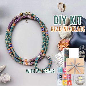 Könnte beinhalten: Ein DIY-Perlenketten-Set mit einer langen, mehrfarbigen Perlenkette und einem passenden Armband. Das Set enthält eine gedruckte Anleitung, kleine Beutel mit sortierten Perlen, zwei Nadeln, eine Garnrolle und eine Geschenkbox mit einer Schleife.