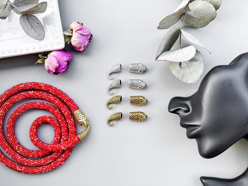 Peut inclure: Un collier de perles rouges avec des embouts en forme de serpent dor&eacute;s. L'image montre &eacute;galement des embouts en forme de serpent argent&eacute;s et dor&eacute;s.