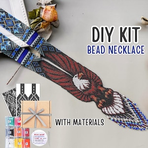 May include: A DIY bead necklace kit featuring a long, woven strap with a bald eagle design in red, white, black, and blue beads. The kit includes a small cardboard gift box with a grey ribbon, printed pattern charts, and labelled bead containers.