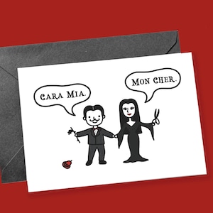 May include: A greeting card featuring a cartoon couple, with the words "Cara Mia" and "Mon Cher" in speech bubbles. The couple is dressed in black and white attire, holding hands. A black envelope is behind the card, set against a red background.