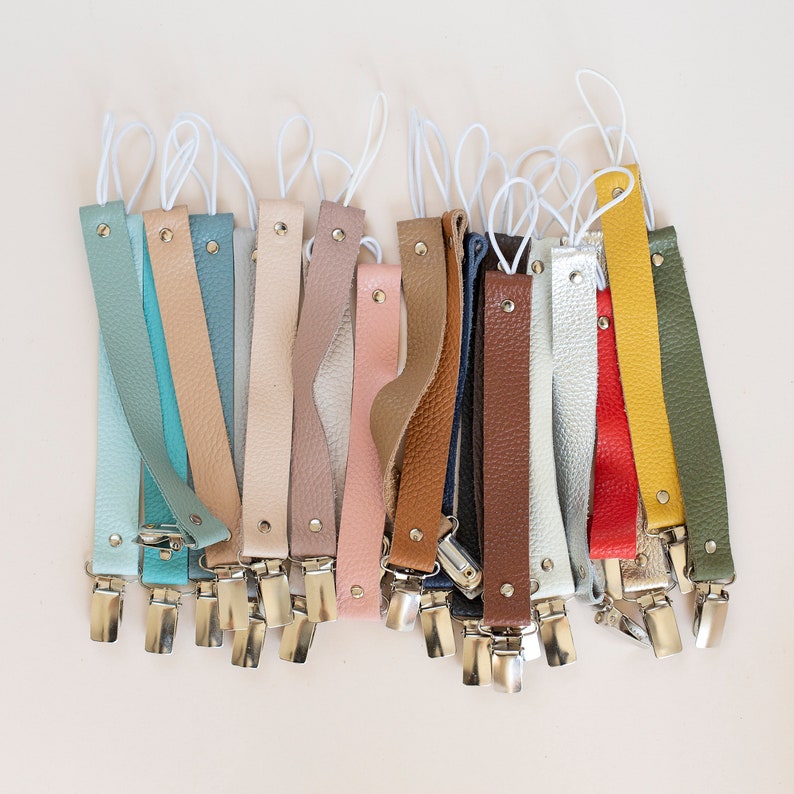 Puede incluir: Una colecci&oacute;n de 18 correas de cuero con clips plateados. Las correas son de varios colores, incluyendo azul, verde, rosa, marr&oacute;n, amarillo y gris.