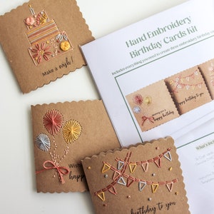 May include: A hand embroidery kit for creating three birthday cards. The kit includes brown cardstock, embroidery floss, and instructions. The cards feature designs of a cake, balloons, and bunting.