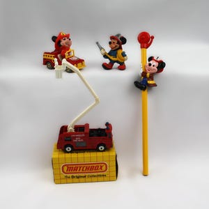 group of authentic vintage Mickey Mouse fire fighter toys and a NOS matchbox fire truck