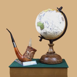 collectible one-of-a-kind hand bent billiard style pipe featuring a robust bowl a carved horned goat & cabin encompassing the entire bowl