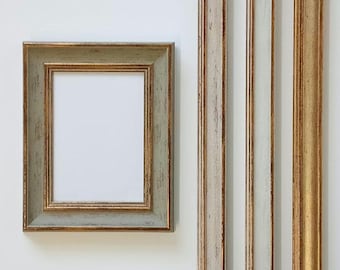 May include: A gold picture frame with a light green outer edge. The frame is empty and ready for a photo or artwork.