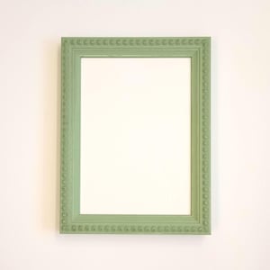 May include: A sage green picture frame with a beaded border. The frame is empty and ready to display a photo or artwork.