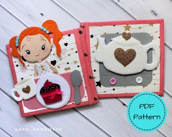 May include: A handmade felt quiet book with a tea party theme. Features a doll, teacup, cupcake, teapot, and spoon. The book has a pink border and is decorated with hearts and stars. The text "PDF Pattern" is in a blue circle.