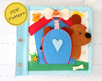 May include: A handmade felt quiet book with a dog theme. The cover is light blue with white polka dots and silver snaps. Inside, a blue dog house with a brown dog, a bone, and a bird. The text "PDF Pattern" is in a yellow circle.