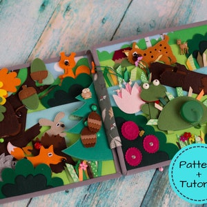 May include: A handmade felt quiet book with a forest theme. The open book features various felt animals, including a fox, squirrel, and frog, set against a backdrop of trees, bushes, and flowers. The text "Pattern + Tutorial" is in a blue circle.