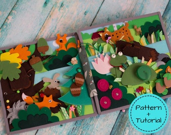 May include: A handmade felt quiet book with a forest theme. The open book features various felt animals, including a fox, squirrel, and frog, set against a backdrop of trees, bushes, and flowers. The text "Pattern + Tutorial" is in a blue circle.