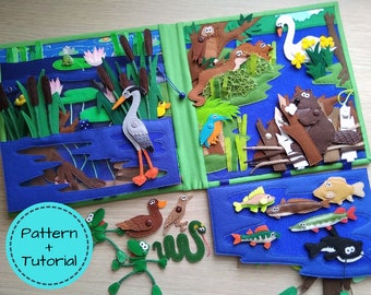 May include: A handmade felt quiet book with aquatic scenes. The book features a heron, frogs, fish, and other animals. The cover has the text "Pattern + Tutorial" in a teal circle. The pages are blue, green, and brown.