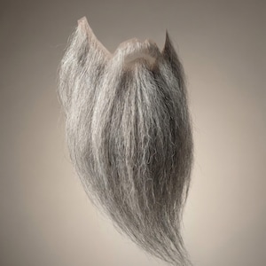 May include: A white ceramic mug with a black handle and the text "But First, Coffee" in a bold, black font. The mug is filled with a dark liquid, likely coffee, and sits on a light-colored surface.