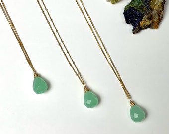 May include: Three gold necklaces with green gemstone pendants. Each necklace features a delicate chain and a teardrop-shaped pendant.