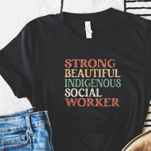 May include: Black t-shirt with the text "STRONG BEAUTIFUL INDIGENOUS SOCIAL WORKER" in a vintage style font.