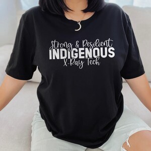 May include: Black t-shirt with white text that reads "Strong & Resilient Indigenous X-Ray Tech".