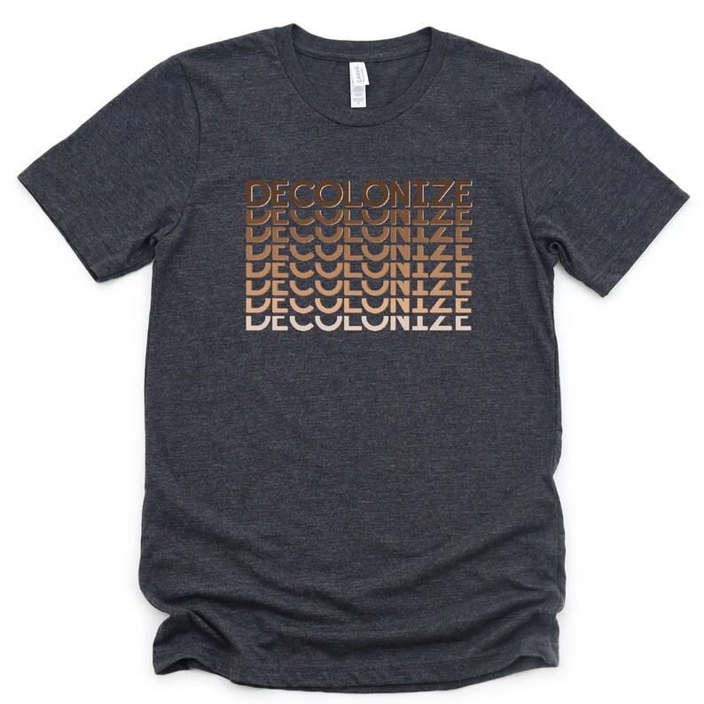 Puede incluir: Una camiseta gris oscuro jaspeada con la palabra "DECOLONIZE" repetida cinco veces en un degradado de tonos marrones.