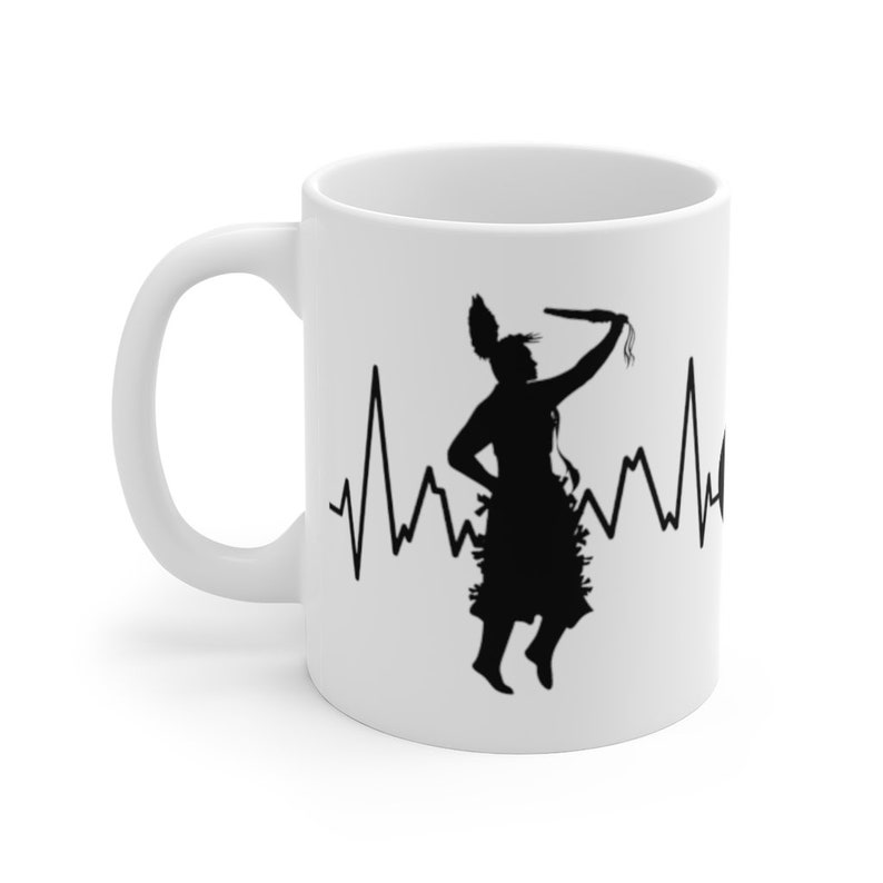 May include: White ceramic mug with a black silhouette of a Native American dancer holding a stick, with a heartbeat line behind the dancer.