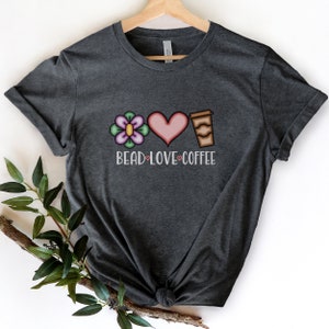 May include: A dark gray t-shirt with a flower, heart, and coffee cup graphic. The text "Bead Love Coffee" is printed below the graphic.