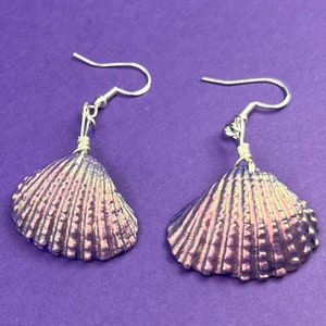 May include: A pair of iridescent purple seashell earrings with silver hooks.