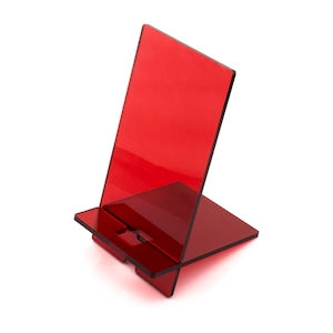 May include: A red acrylic phone stand with a rectangular base and a tall, angled back.