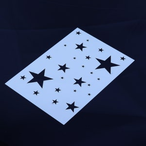May include: White stencil with a design of multiple black stars of different sizes.