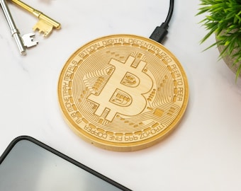 May include: A wooden wireless charging pad with a Bitcoin logo and the text "TRCHZ 999 FINE COPPER LUB MONETARY METALS BITCOIN DIGITAL DECENTRALIZED PEER TO PEER".