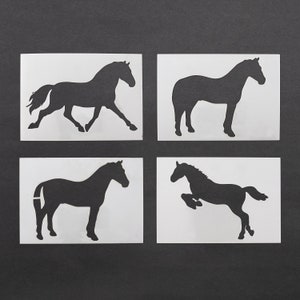 Peut inclure: Quatre décalcomanies de silhouettes de chevaux noirs sur des rectangles blancs sur fond sombre. Les chevaux sont dans diverses poses : course, debout et saut. Les décalcomanies sont probablement destinées à l'artisanat ou à la décoration.