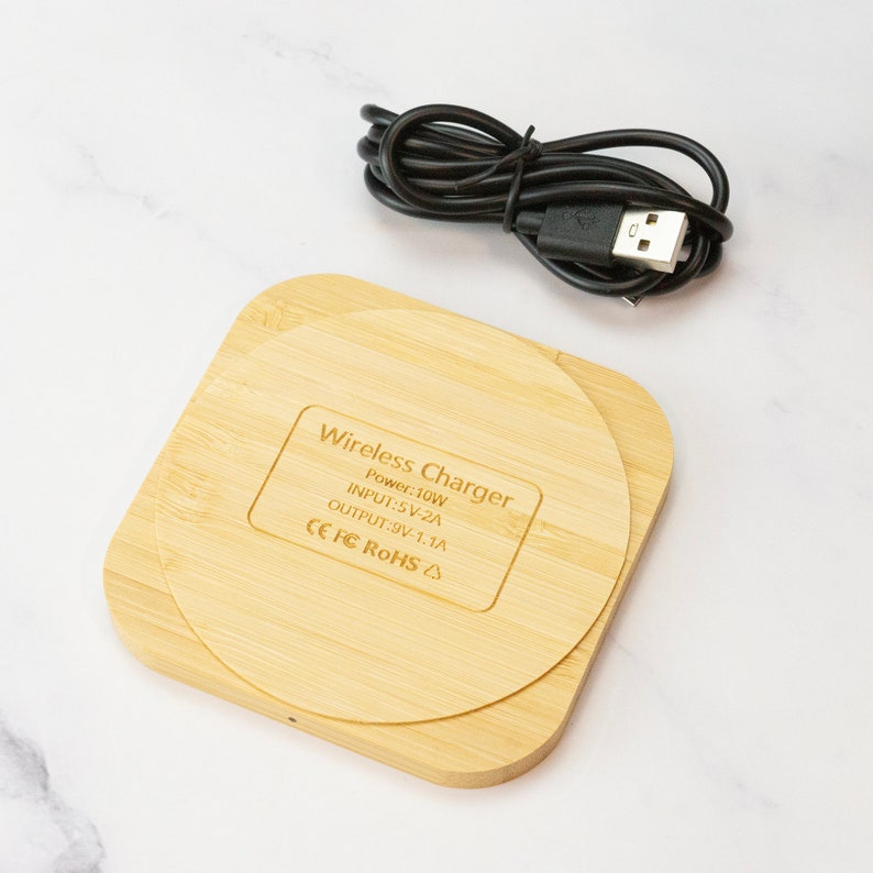 May include: A wooden wireless charger with a USB cable. The charger has the text "Wireless Charger", "Power: 10W", "INPUT: 5V-2A", "OUTPUT: 9V-1.1A", "CE FC ROHS" printed on it.