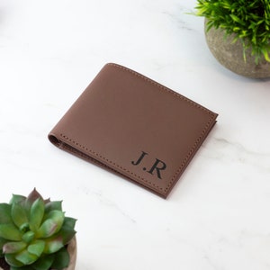 May include: A brown leather wallet with the initials "J.R." embossed in black.