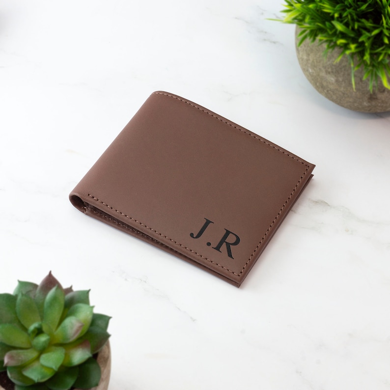 May include: A brown leather wallet with the initials "J.R." embossed in black.