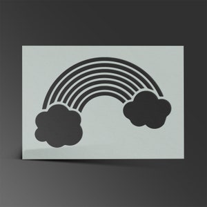 Peut inclure: Un pochoir représentant un arc-en-ciel noir avec deux nuages sombres. L'arc-en-ciel comporte plusieurs lignes courbes et les nuages sont de forme arrondie. Le pochoir est sur un fond gris clair.