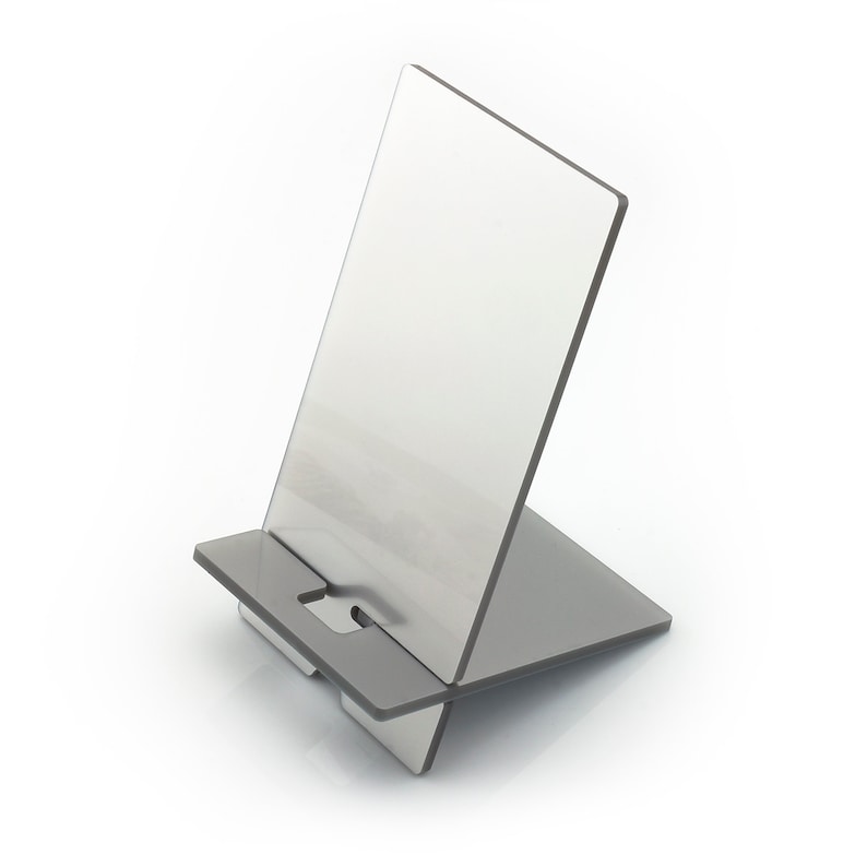 May include: A silver metal phone stand with a rectangular base and a raised back for propping up a phone or tablet.