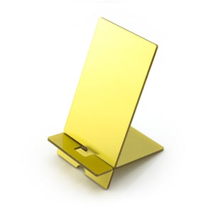 May include: A gold-colored metal phone stand with a rectangular base and a raised back for propping up a phone.