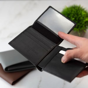 May include: Black leather wallet with multiple card slots and a clear ID window. The wallet is open and has the text "YOUR TEXT HERE" embossed on the front.