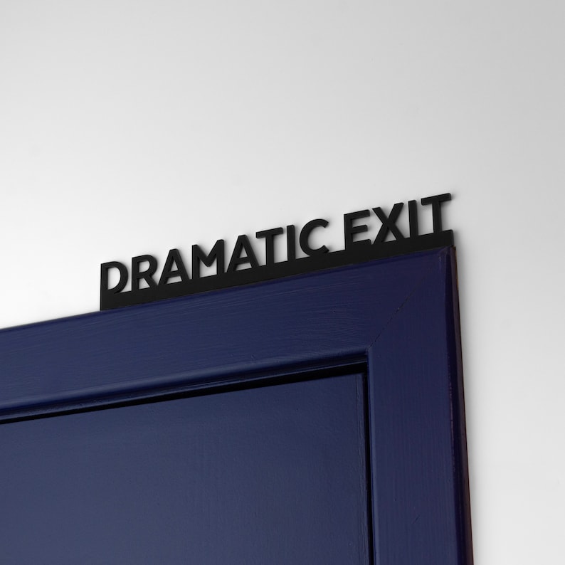 K&ouml;nnte beinhalten: Eine dunkelblaue T&uuml;r mit einem schwarzen Schild, auf dem "Dramatic Exit" steht.