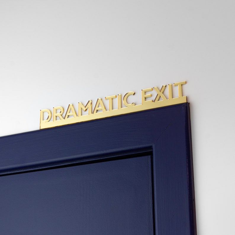 K&ouml;nnte beinhalten: Eine dunkelblaue T&uuml;r mit einem goldenen Schild mit der Aufschrift "Dramatic Exit".