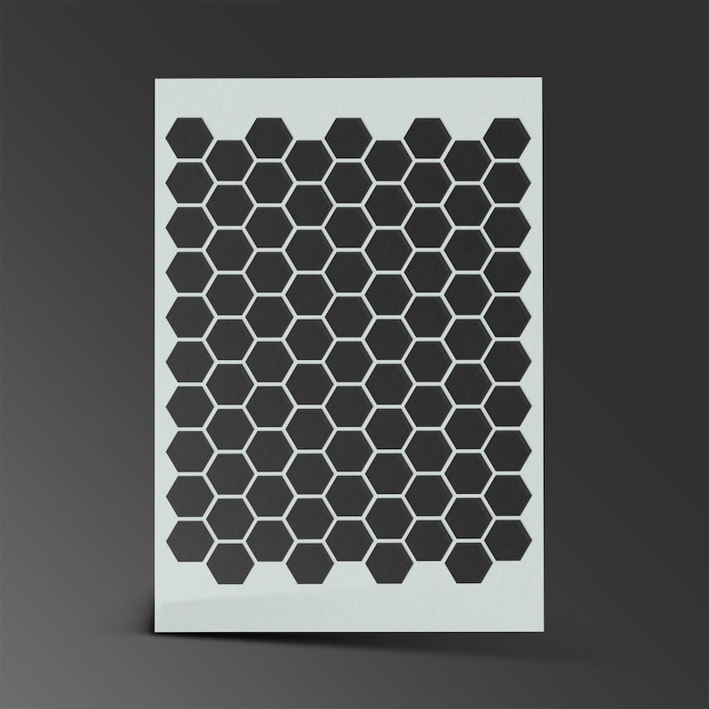 May include: A white stencil with a black honeycomb pattern. The stencil is made of a thin, flexible material and is designed for use with paint or other mediums.