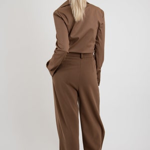 May include: A brown pantsuit with a long-sleeved collared shirt and wide-leg pants.