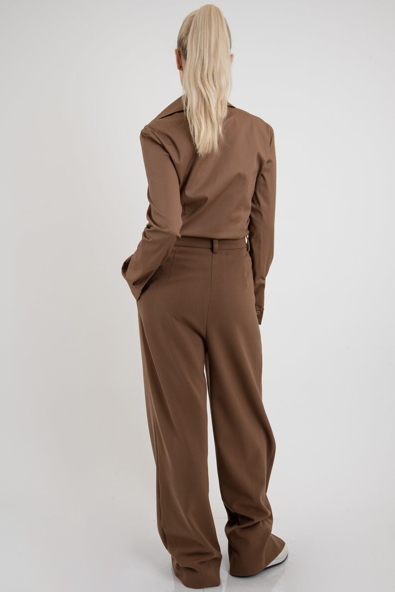 May include: A brown pantsuit with a long-sleeved collared shirt and wide-leg pants.