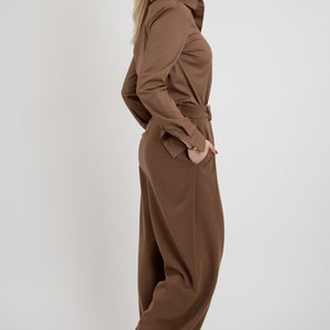 May include: A brown long-sleeved shirt with a collared neckline and a matching pair of wide-leg pants.