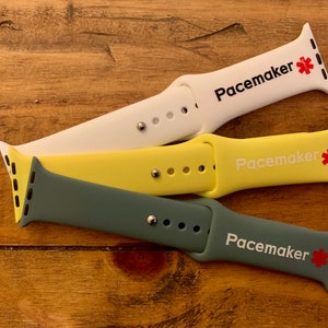 May include: Three different colored silicone watch bands with the word "Pacemaker" and a red star printed on them. The bands are white, yellow, and green.