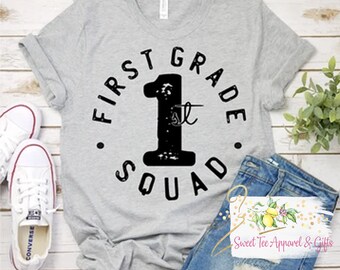 May include: Gray t-shirt with black text that reads "First Grade 1st Squad".