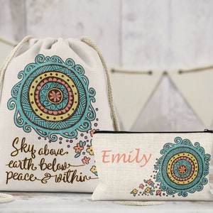 May include: A drawstring backpack and a small zippered pouch. Both are off-white with a mandala design in teal, yellow, and pink. The backpack has the text "Sky above earth below peace & within." The pouch has the name "Emily."