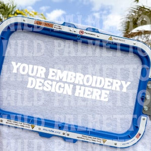 Puede incluir: Un bastidor de bordado azul con el texto blanco "YOUR EMBROIDERY DESIGN HERE". El bastidor tiene advertencias sobre imanes y riesgo de pellizco. El texto "DIGITAL DOWNLOAD" está en la parte superior.