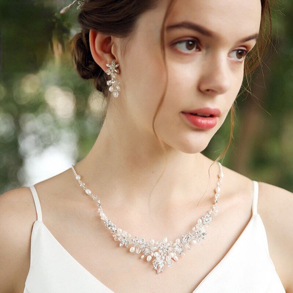 L’ensemble de collier, boucles d’oreille et vigne de cheveux mariage. The set of necklace, earrings and vine of wedding hair.