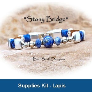 Könnte beinhalten: Ein Armband mit dem Text "Stony Bridge" zeigt blaue Lapislazuli-Perlen und silberfarbene Metallakzente. Das Armband hat ein Lederband und ist Teil eines Zubehör-Kits. Das Design umfasst blaue Kordel und silberne Perlen.